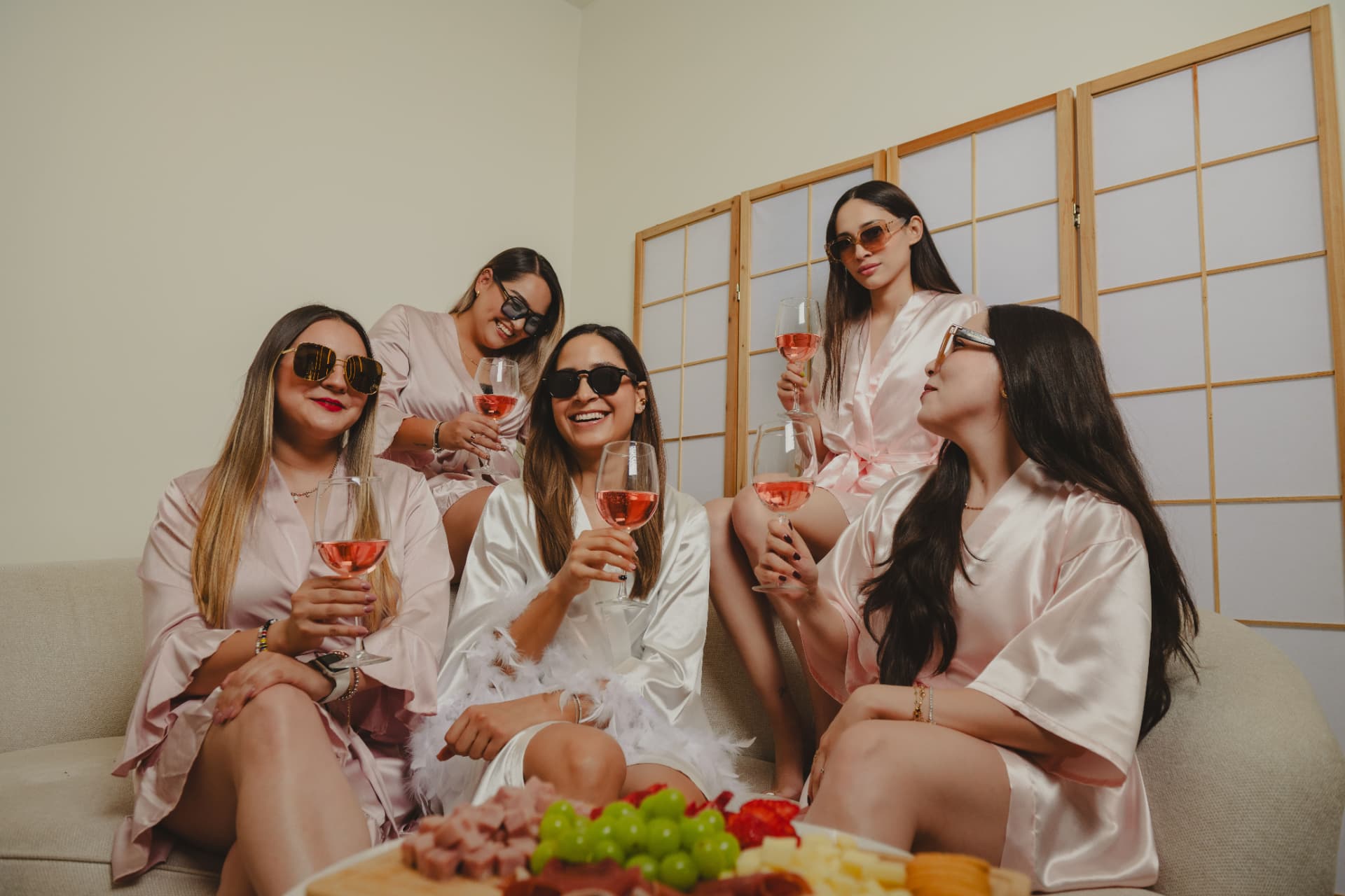Amigas brindando en bata rosa dentro del spa