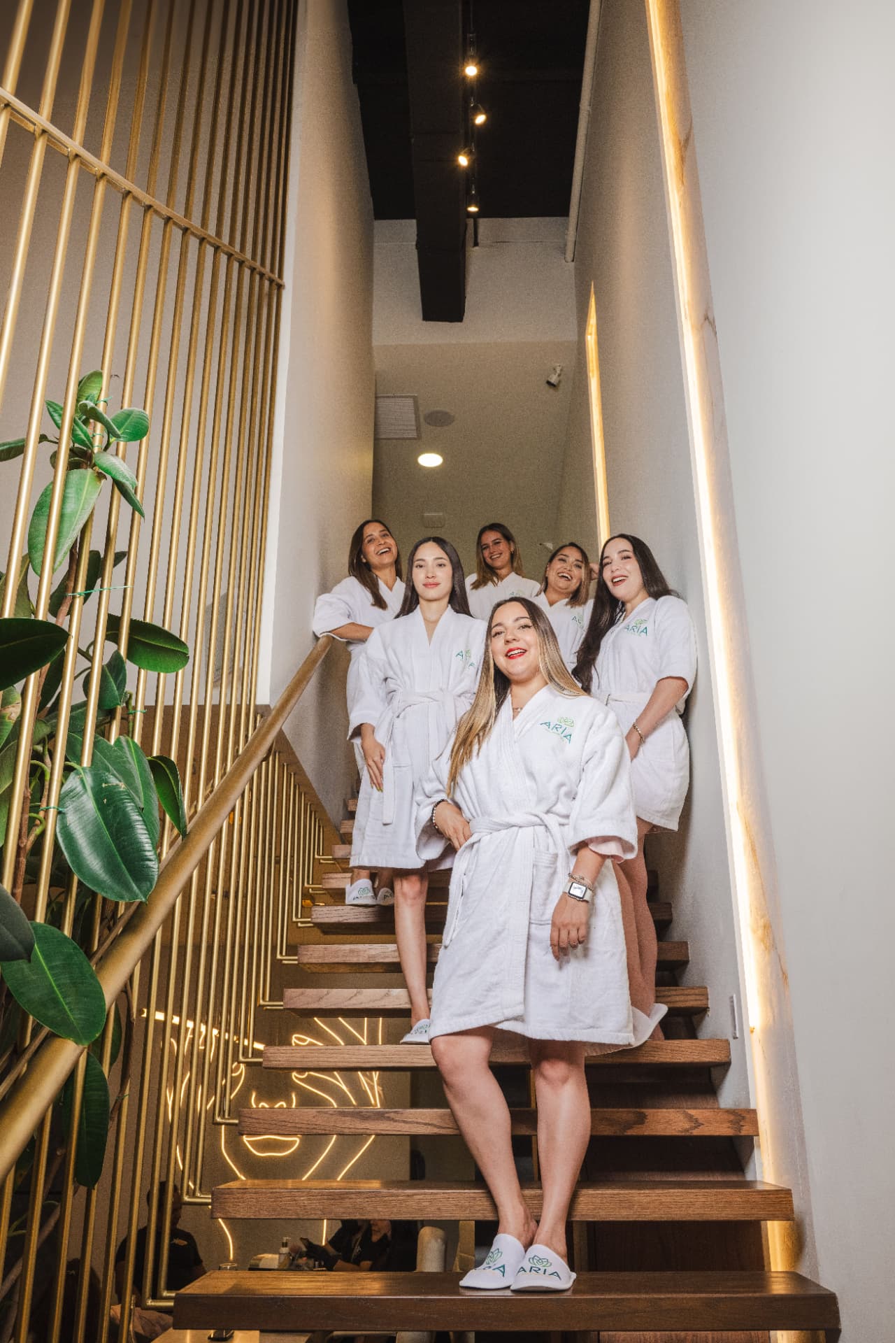 Grupo de amigas en bata en las escaleras de Aria Wellness Spa